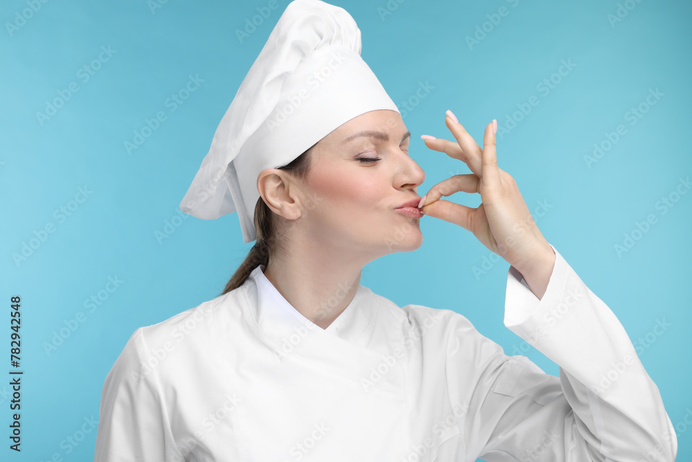 Canvas Prints Woman chef in uniform showing perfect sign on light blue background