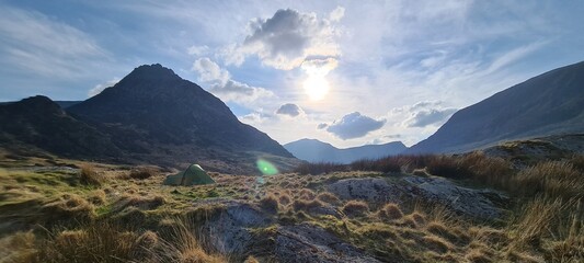 Beautiful shot of camping tents placed under a huge Glyder Fach mountain