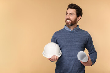 Architect with hard hat and draft on beige background, space for text
