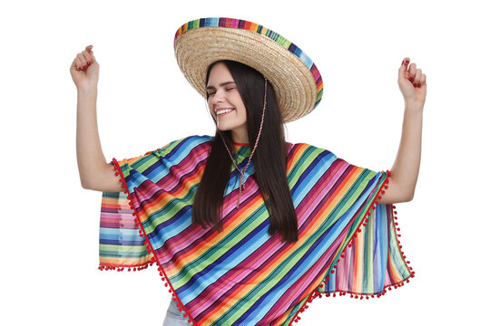 Young woman in Mexican sombrero hat and poncho dancing on white background