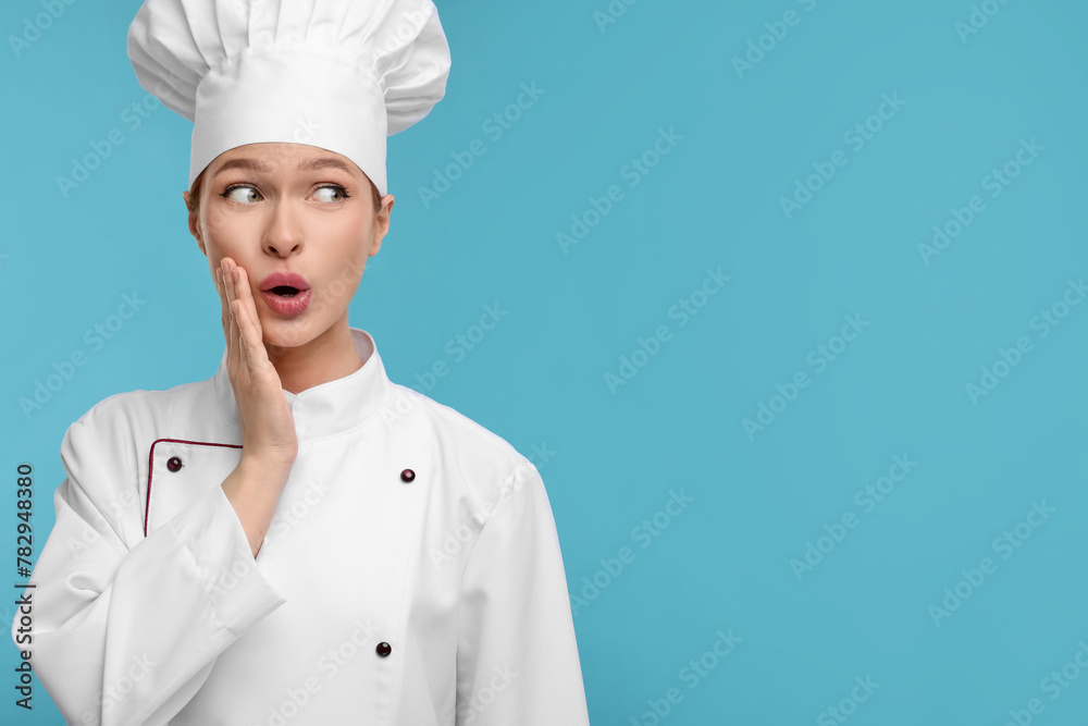 Canvas Prints Happy woman chef in uniform on light blue background, space for text