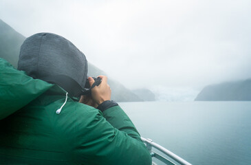 Tourist taking photos of Holgate Glacier in the storm. Kenai Fjords National Park. Alaska. - 782949127