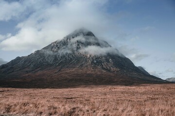 Fototapeta premium Beautiful view of the Buachaille Etive Mor covered in clouds in Glencoe