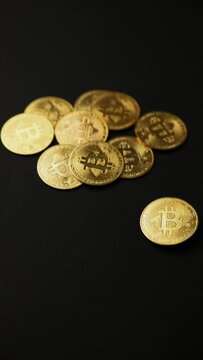 Close up of a bitcoin golden coin rotating on a black background, vertical shot. Bullish BTC, cryptocurrency, 2p2 exchange and blockchain concept