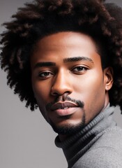 Man with an afro in a grey sweater.