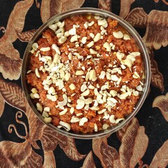 Top view of Gajar halva with carrot, cashew, and pistachio nuts in a bowl