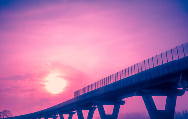 View of the road bridge through the windshield. Beautiful evening landscape with bridge and dramatic sunset sky