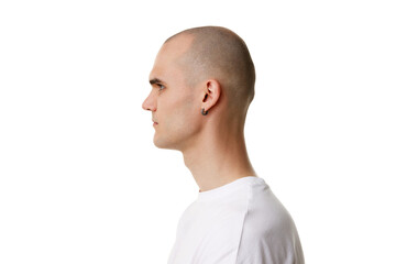 Side, profile view of young man with bald head and shaved face, ear piercing standing in white...