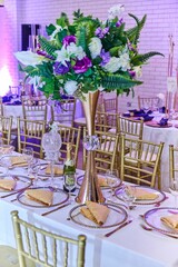 Vertical of the utensil of tables set and decorated with flower bouquets in a wedding hall, venue
