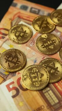 Close up of several gold bitcoin coins on 50 euro bills, camera panning movement. Bullish BTC, cryptocurrency, 2p2 exchange and blockchain concept