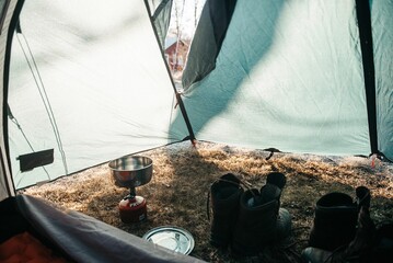 Pairs of boots and a gas burner inside a tent