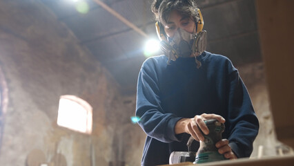 Woman carpenter sanding wood block. Feminist girl process timber bar. Male carpentry work skill....