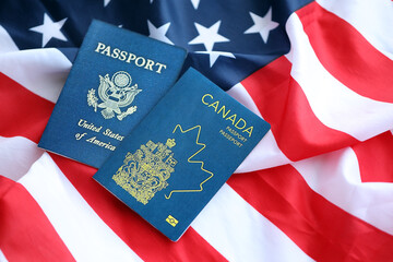 Passport of Canada with US Passport on United States of America folded flag close up
