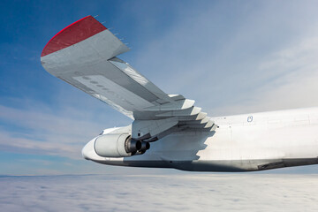 White wide body transport cargo airplane fly in the air above the clouds