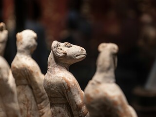 Selective focus of the figurine of an East Asian animal with a human body on a blurry background