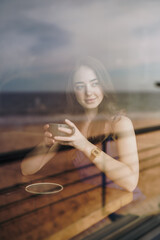 Woman drinking tea sitting in a cafe - 782970328