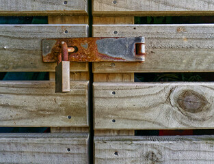 Rusty lock, hasp and staple on a barn door.