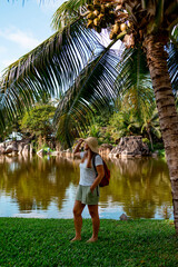 middle aged woman plus size travels in the Seychelles with a map and backpack, hiking and trekking on a tropical island