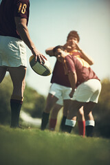 Hand, rugby and team with ball on grass field for training together, competition and cardio workout. Group of athletes, teamwork and sports uniform outdoor for practice game, sunshine and exercise - obrazy, fototapety, plakaty