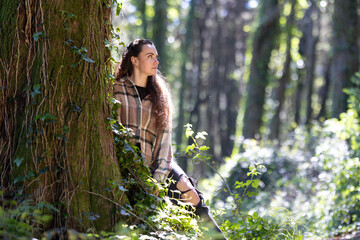 Woman Standing Next to Tree in Forest