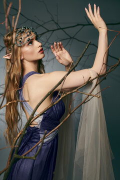 A young woman in a striking blue dress stands elegantly in front of a majestic tree in a studio setting, embodying an elf princess.