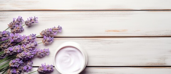 Obraz na płótnie Canvas Cream Jar and Lavender Flowers on Wooden Surface