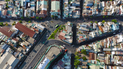 Amazing aerial view by drone of Ho Chi Minh, big Asian city, crowded townhouse, vehicle circulate on street move to intersection, house close together residence area