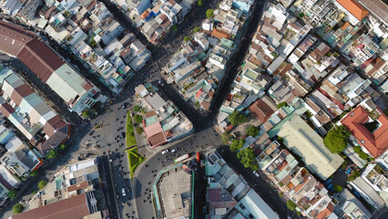 Amazing aerial view by drone of Ho Chi Minh, big Asian city, crowded townhouse, vehicle circulate on street move to intersection, house close together residence area