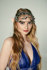 A young woman in a blue dress with a crown on her head, embodying the essence of a fairy princess in a mystical, studio setting.