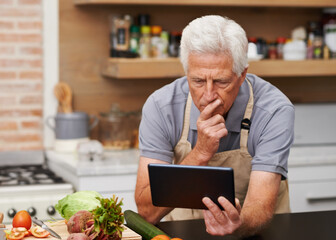Senior man, tablet and vegetables for cooking wholesome, healthy and nutritional food at home. Retired male, ingredients and digital device for researching diet, recipes and delicious vegan meals