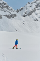 Fototapeta na wymiar A Skier Scales a Treacherous Alpine Peak