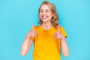 Happy woman student showing thumb ups on two hands - obrazy, fototapety, plakaty