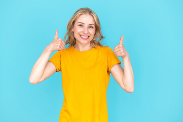 Excited smiling young woman in casual wear showing thumbs up