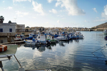 Panorama con barche nel porto di favignana con sfondo di cielo azzurro e nuvole bianche sicilia italia isole mare