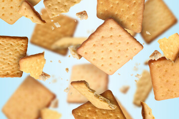 Tasty dry crackers falling on light blue background