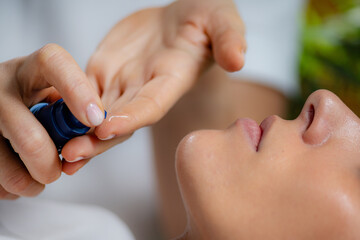 Cosmetician applying retinol serum on woman's face, known for its anti-aging benefits and skin rejuvenation