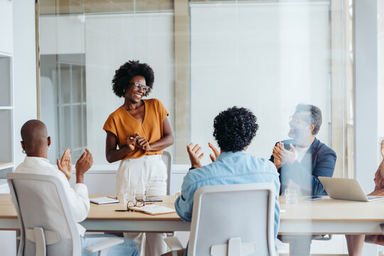 Successful business team applauding and celebrating their project at a happy boardroom meeting