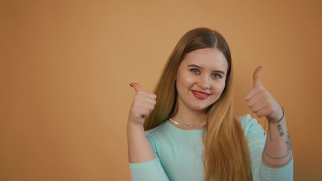 Young joyful woman raising thumbs up. Portrait of girl showing hand gesture approval support agree recommendation raises thumb up good fine sign. Perfect emotions, success competition, luck concept.