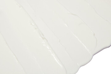 White cosmetic cream smeared on a blank background.