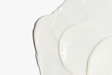 White cosmetic cream smeared on a white background.