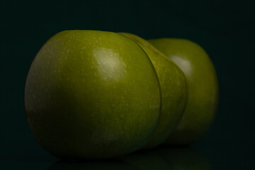 Three green apples (Granny Smith) on black background