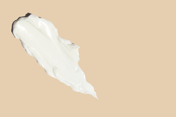 smears of cosmetic cream on a beige background.
