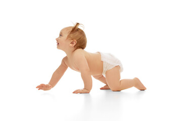 Happy, smiling little baby girl, child in diaper crawling isolated on white studio background. Playing and having fun. Concept of childhood, care, health, well-being, parenthood