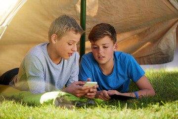 Children, phone and tent on grass for camping, virtual games and outdoor recreation on holiday....