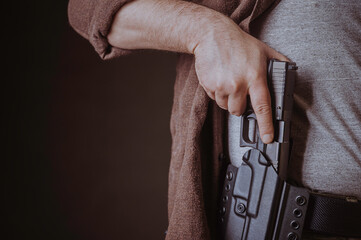 A gun in a holster, delicately hidden under his shirt.