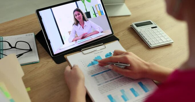 Female marketer discusses a financial report with a colleague during a video call