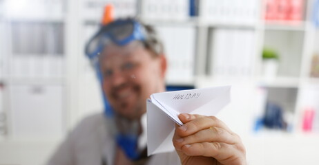 Man wearing suit and tie in goggle and snorkel play with fly papers plane in office closeup. Count...