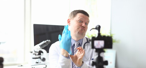 Male doctor pull on hand blue protective medical gloves. Online treatment assignment concept