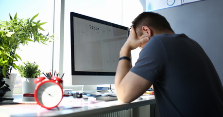 Sad upset male worker hold his head solving business problem or private life troubles at office workplace concept