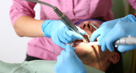 Female hand in blue protective gloves conducts professional oral hygiene closeup. Patient on admission to the dentist paid clinic payment for health insurance concept